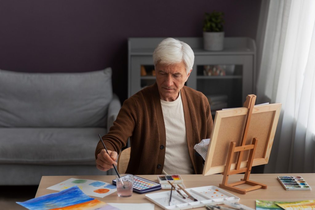 Senior man painting in an indoor setting