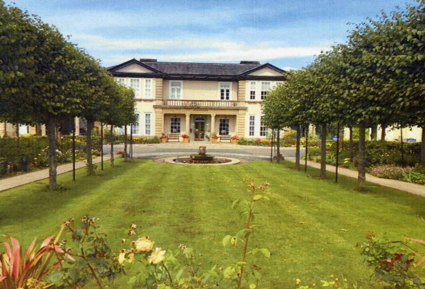 Exterior view of Hollins Hall surrounded by landscaped gardens