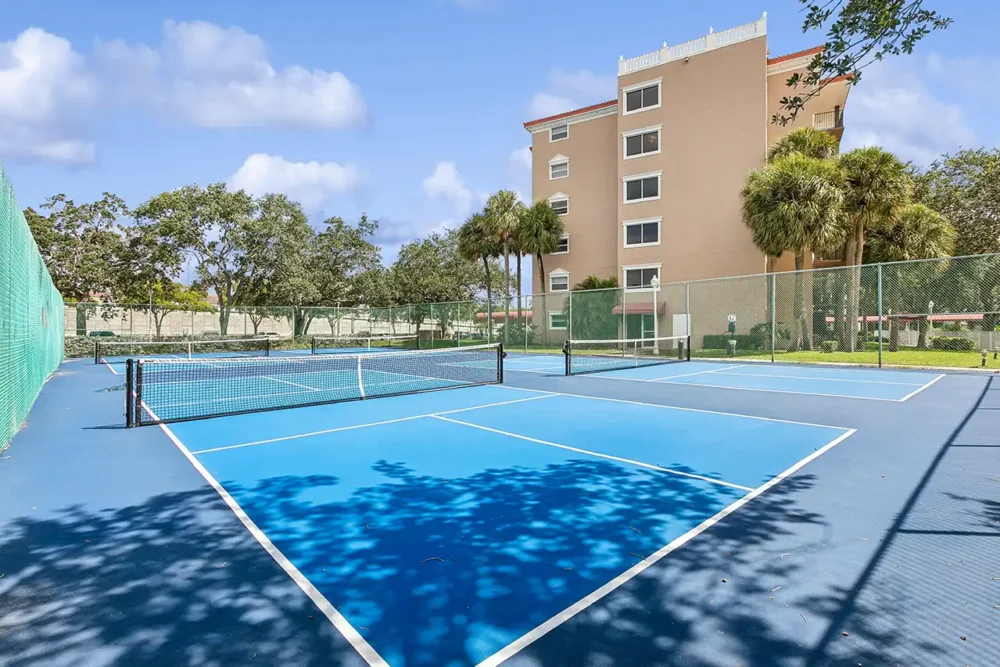 Tennis court with a residential building in the background