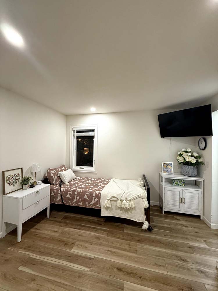 Brightly decorated resident bedroom with a cozy bed