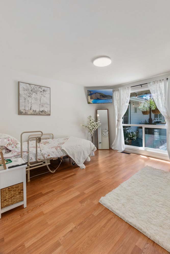 Bright resident room with natural light and wooden flooring