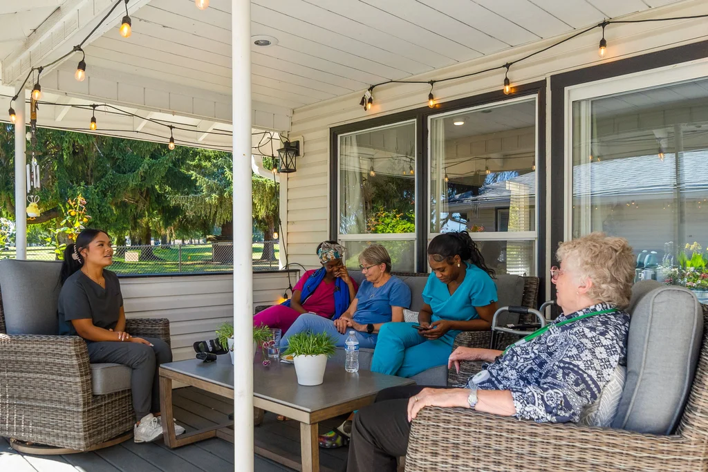 Residents and staff enjoying conversation on a patio