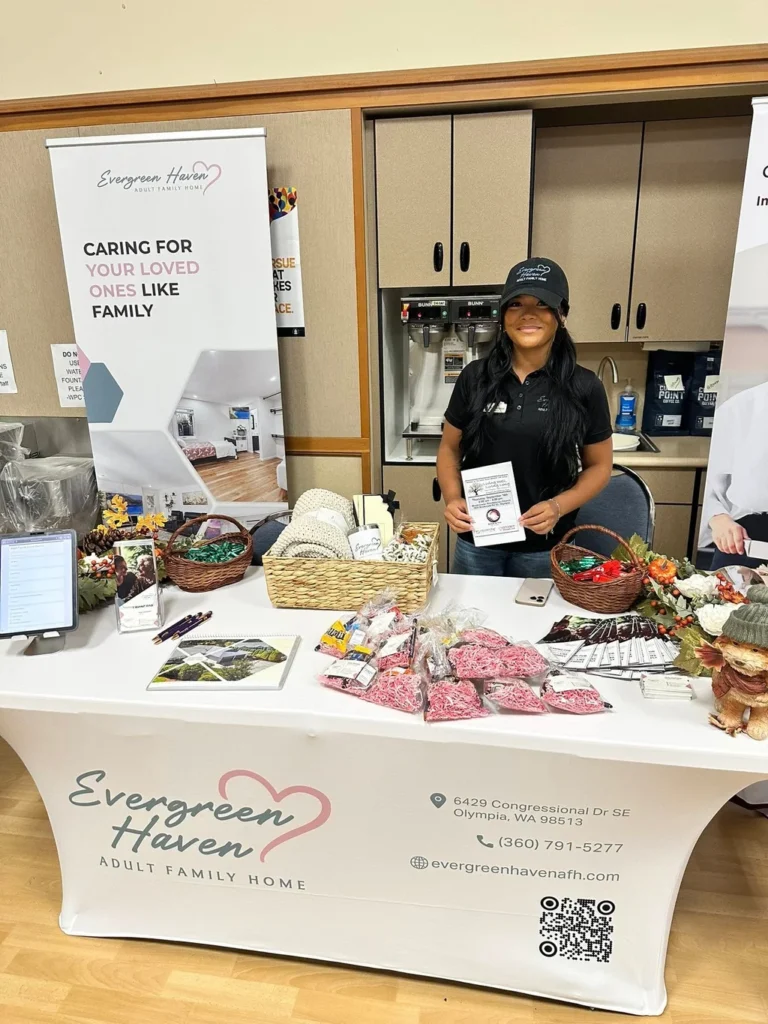 A staff member at a table displaying snacks and information