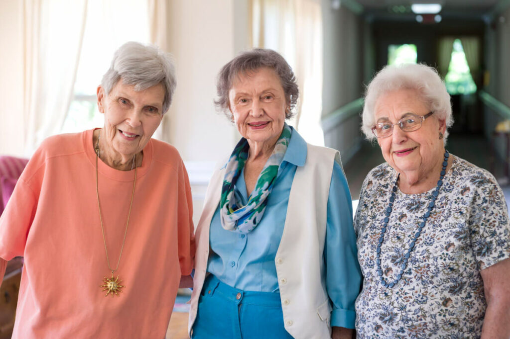 Three female residents smiling in a hallway