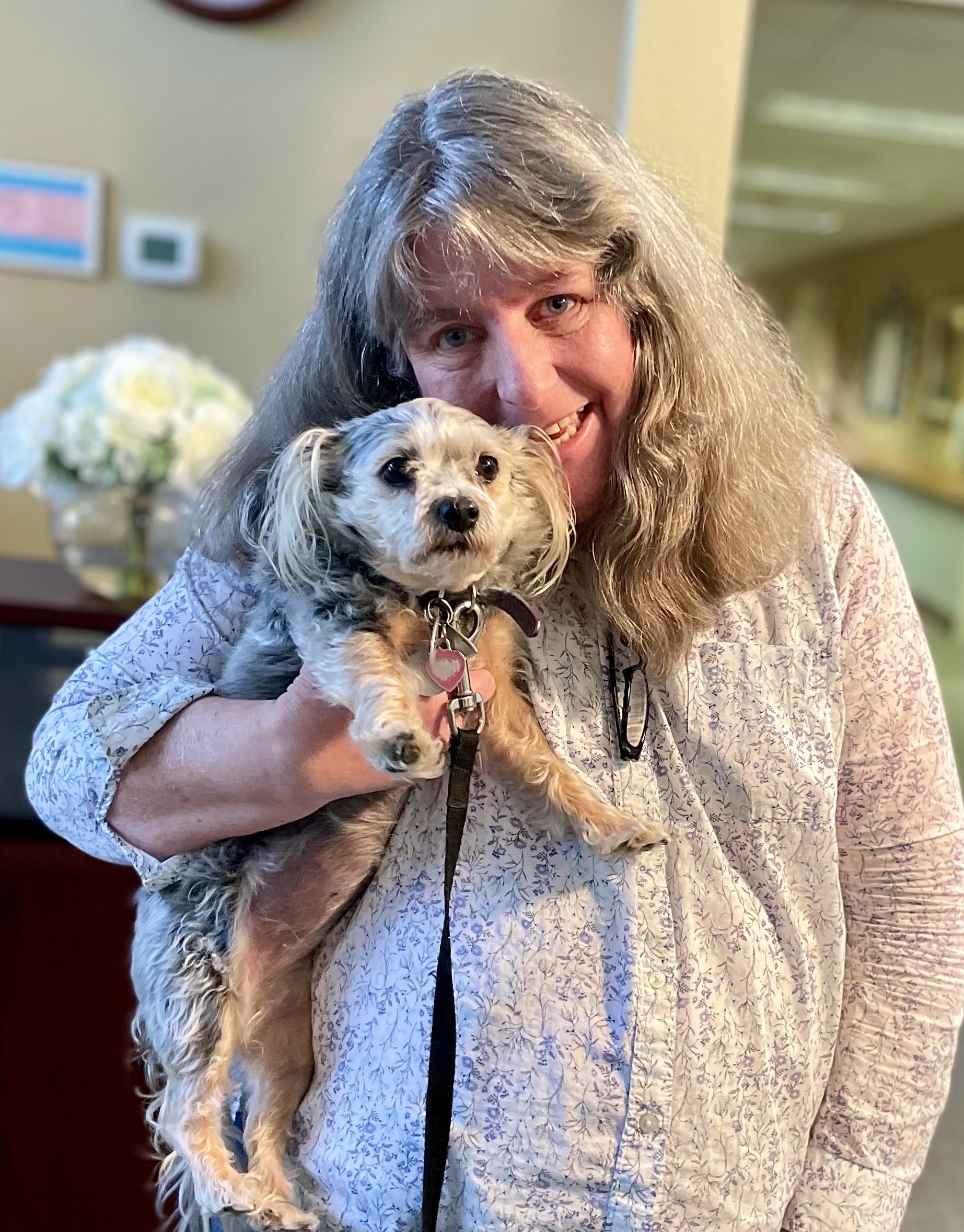 Staff member holding a small dog inside the facility