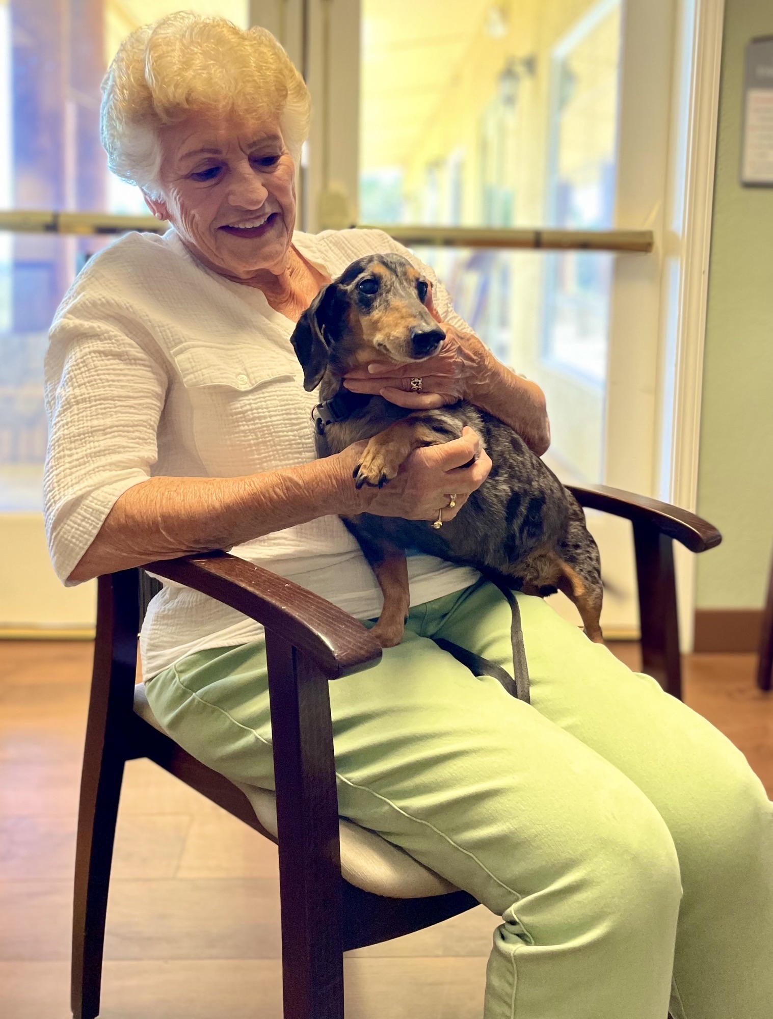 Resident interacting with a dog in a common area