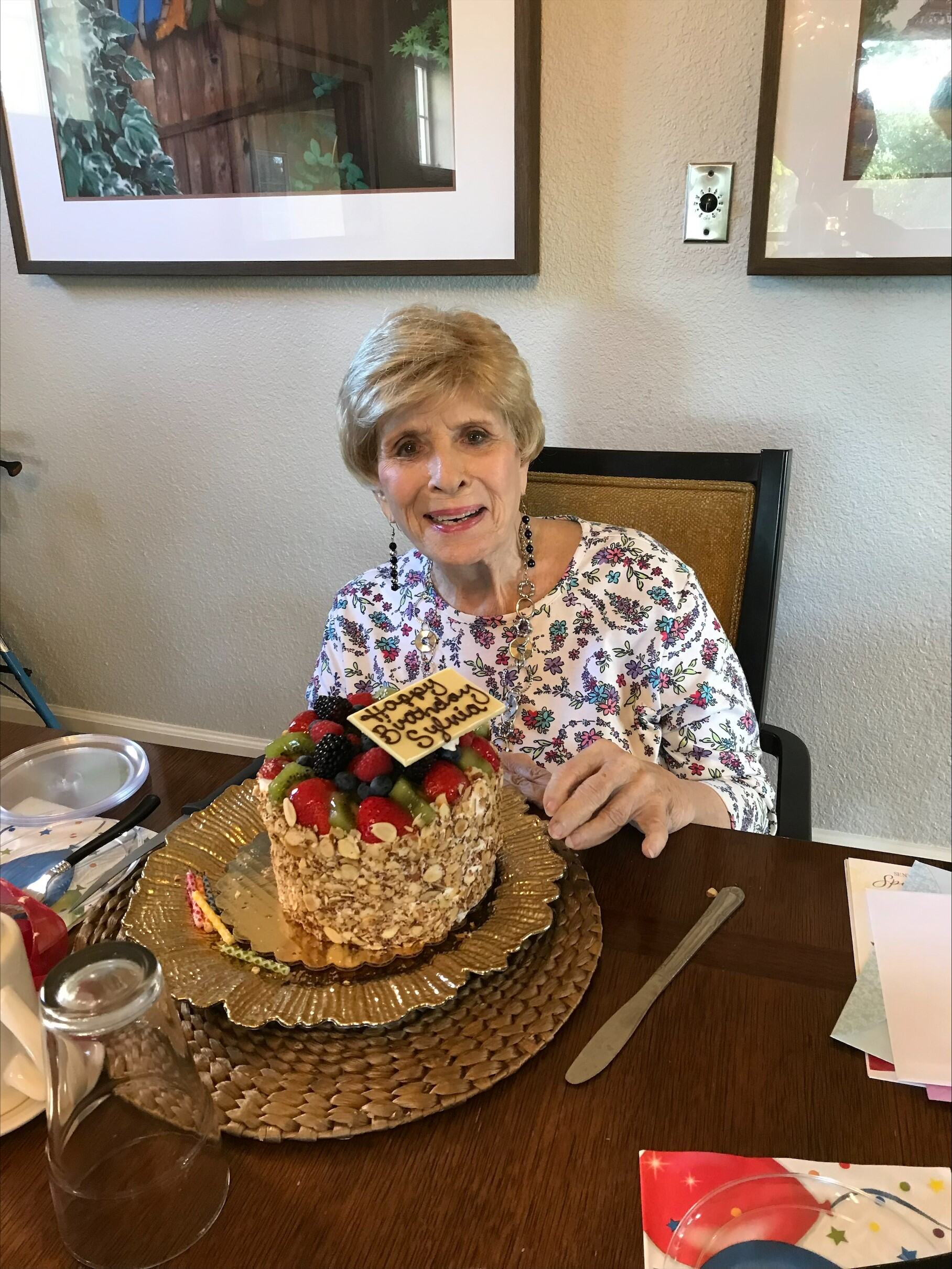A resident celebrating with a cake at the table