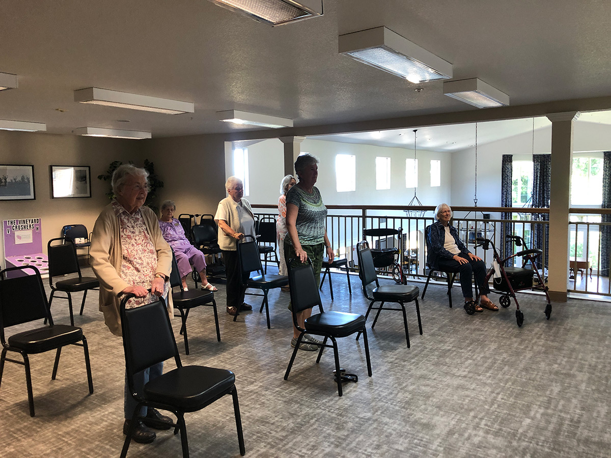 Residents in a common area with chairs arranged for an event