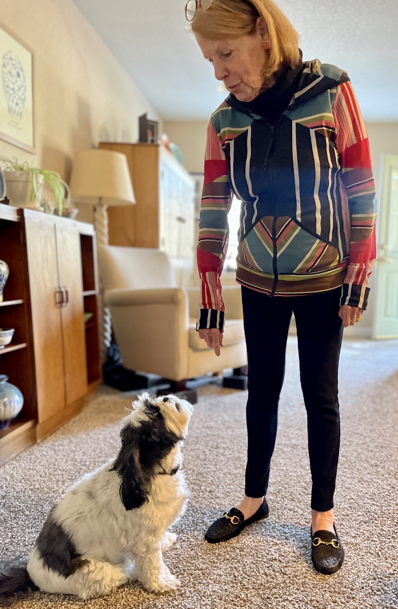 A resident interacting with a dog in a cozy common area
