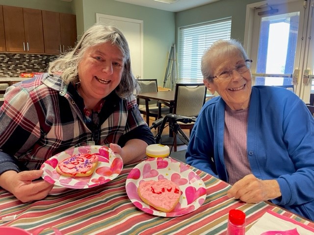 Residents decorating heart-shaped cookies during an activity