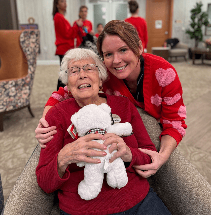 Resident and staff member embracing in a cozy common area