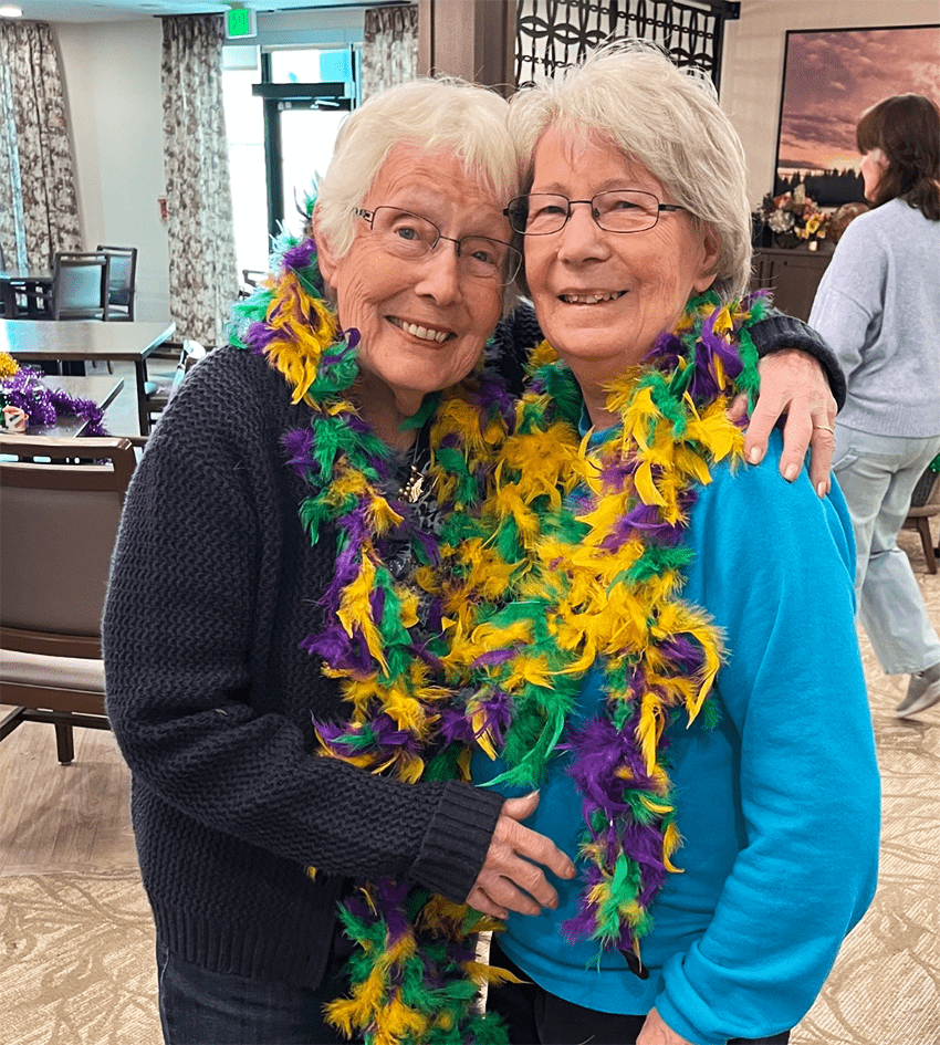 Two residents enjoying a festive event in the community room