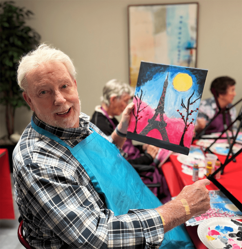 Resident participating in an art activity with a painting