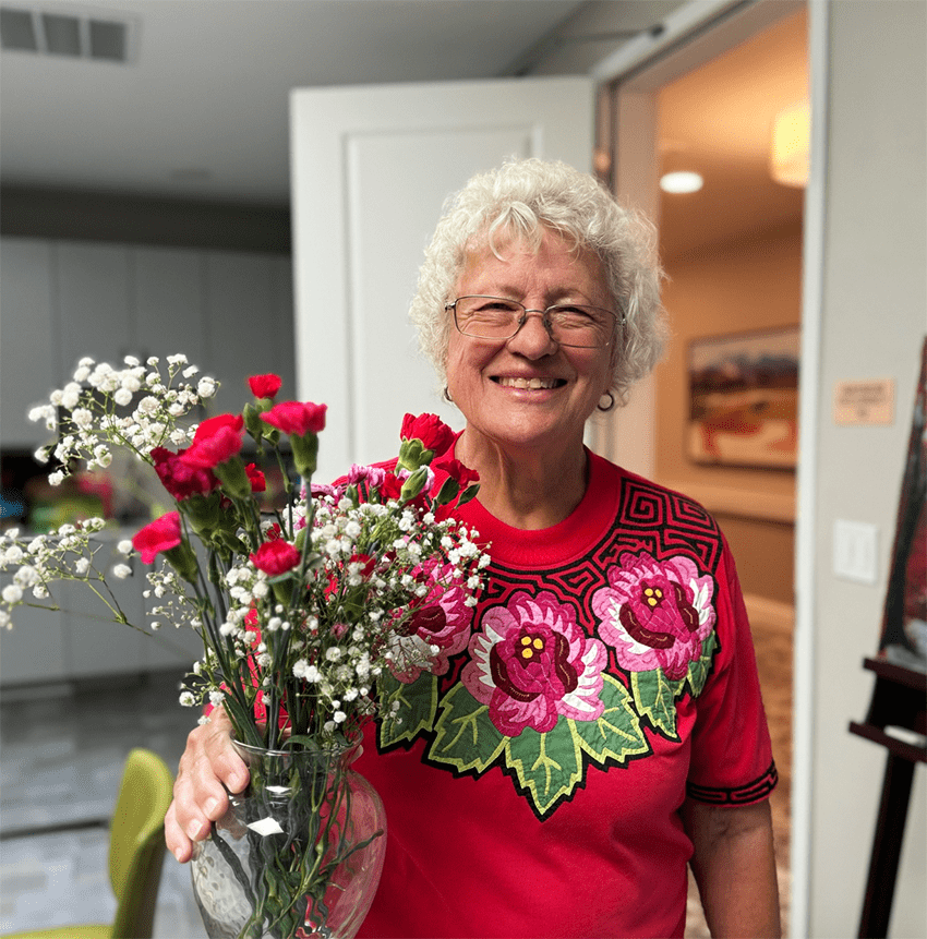 Resident holding a vase of flowers in a common area