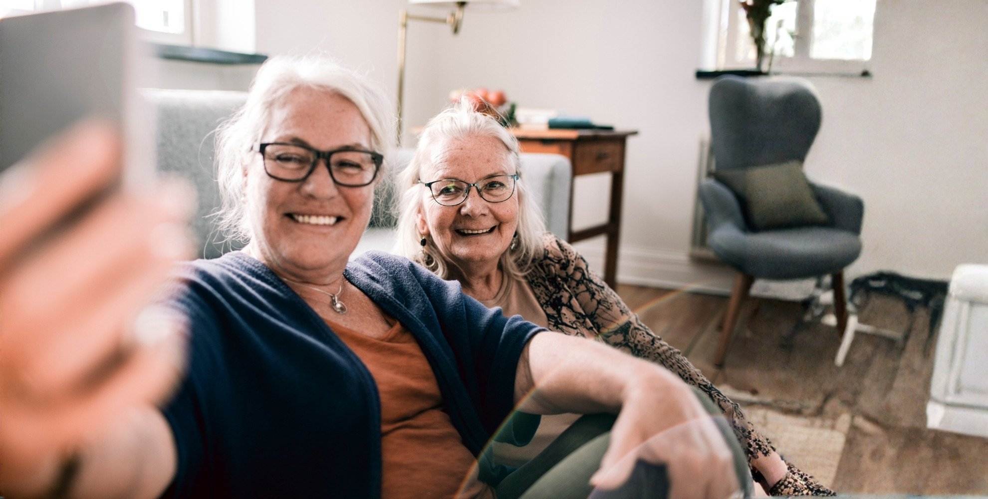 Residents smiling and taking a selfie in a cozy lounge