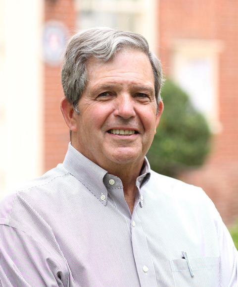 A smiling older man in a collared shirt