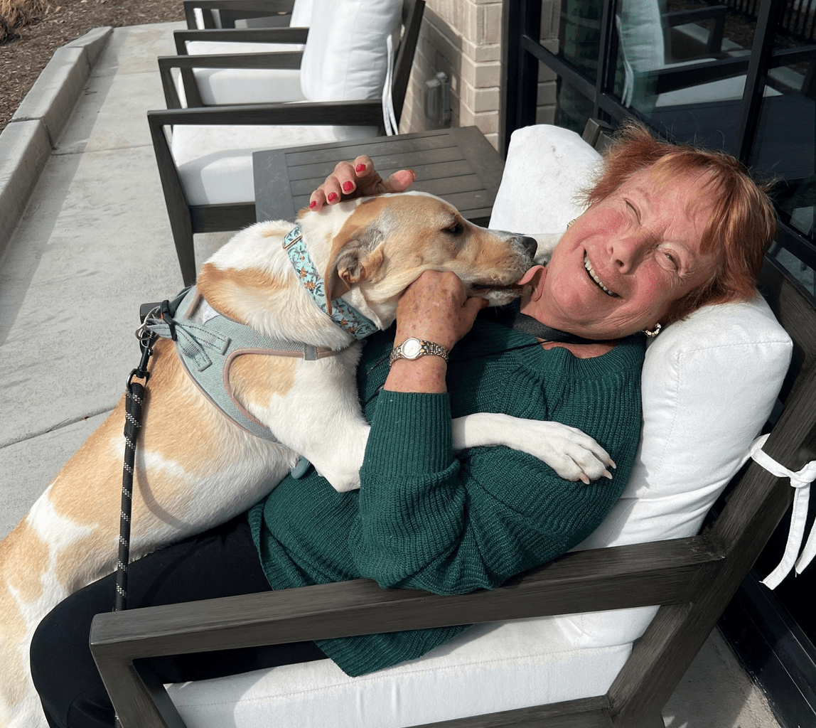 Resident enjoying time with a dog outdoors