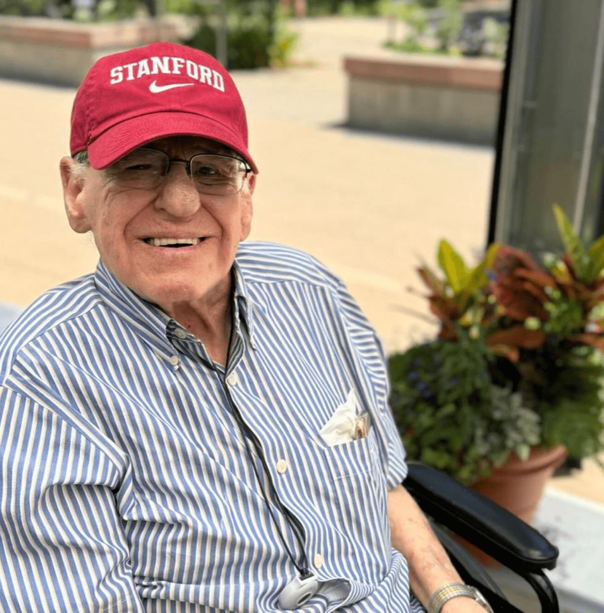 Happy resident in wheelchair outdoors with plants