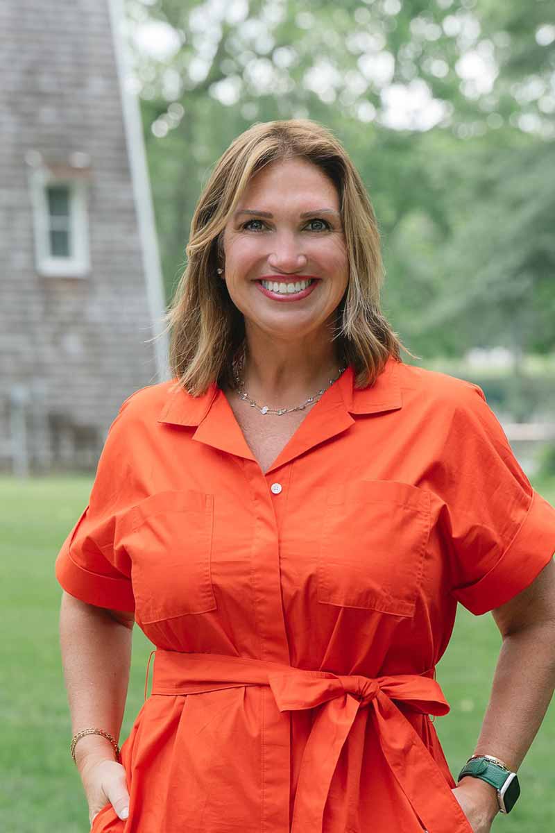 Smiling woman in an orange dress outdoors