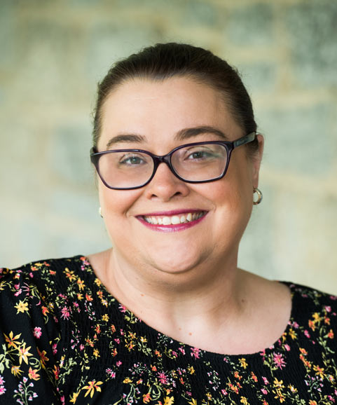 Smiling staff member in a floral blouse