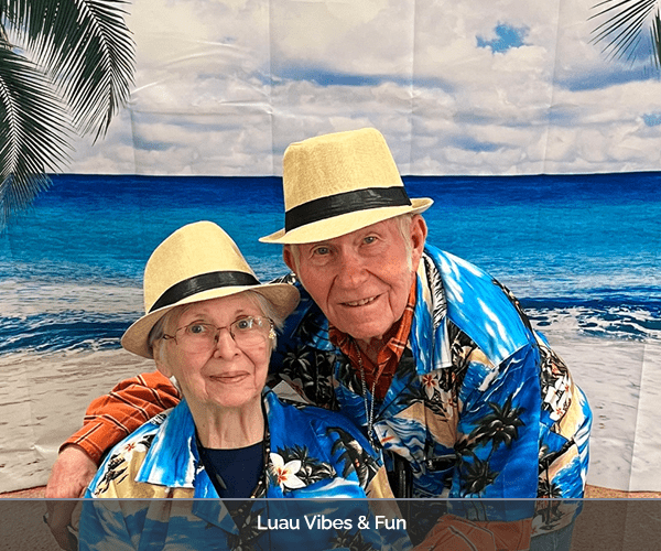 Two residents enjoying a luau theme event