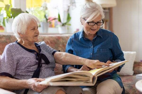 Two residents engaging with a photo album in a cozy setting