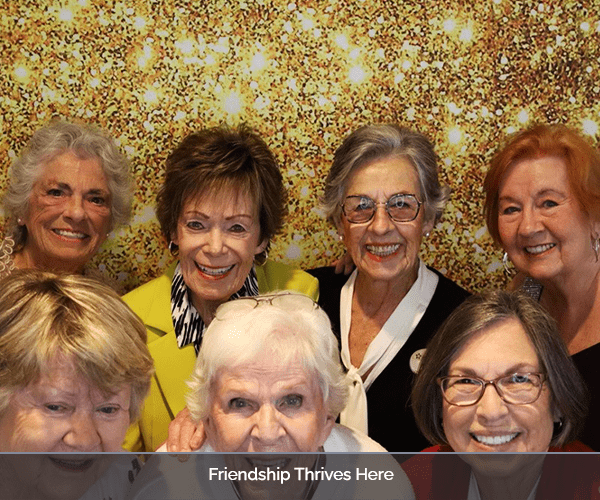 Group of smiling senior women with a celebratory backdrop