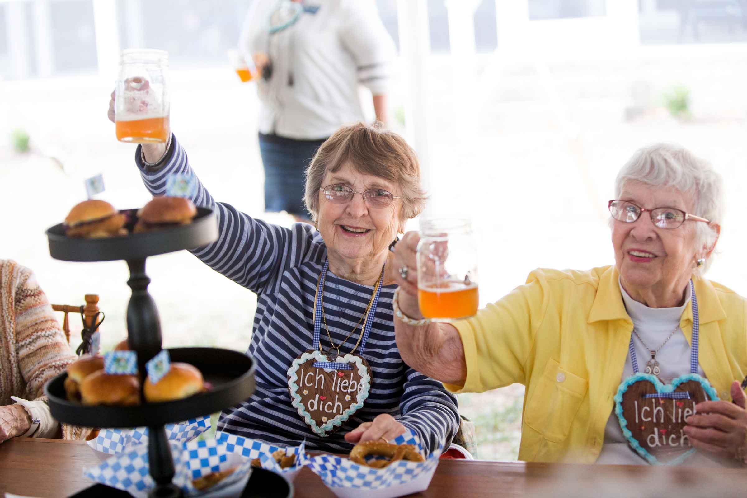 Two residents celebrating with drinks and food at an event