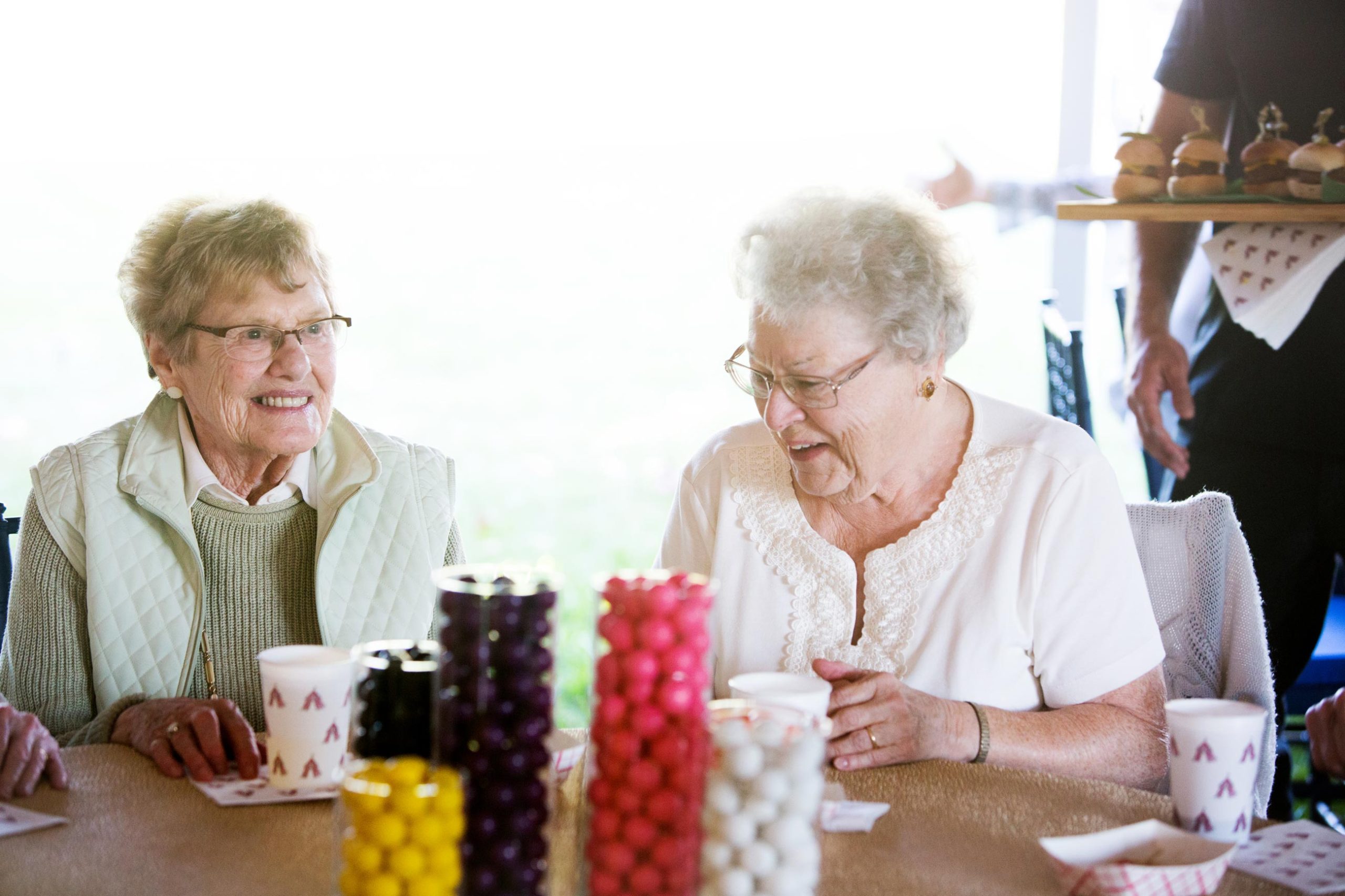 Two seniors enjoying refreshments and smiling