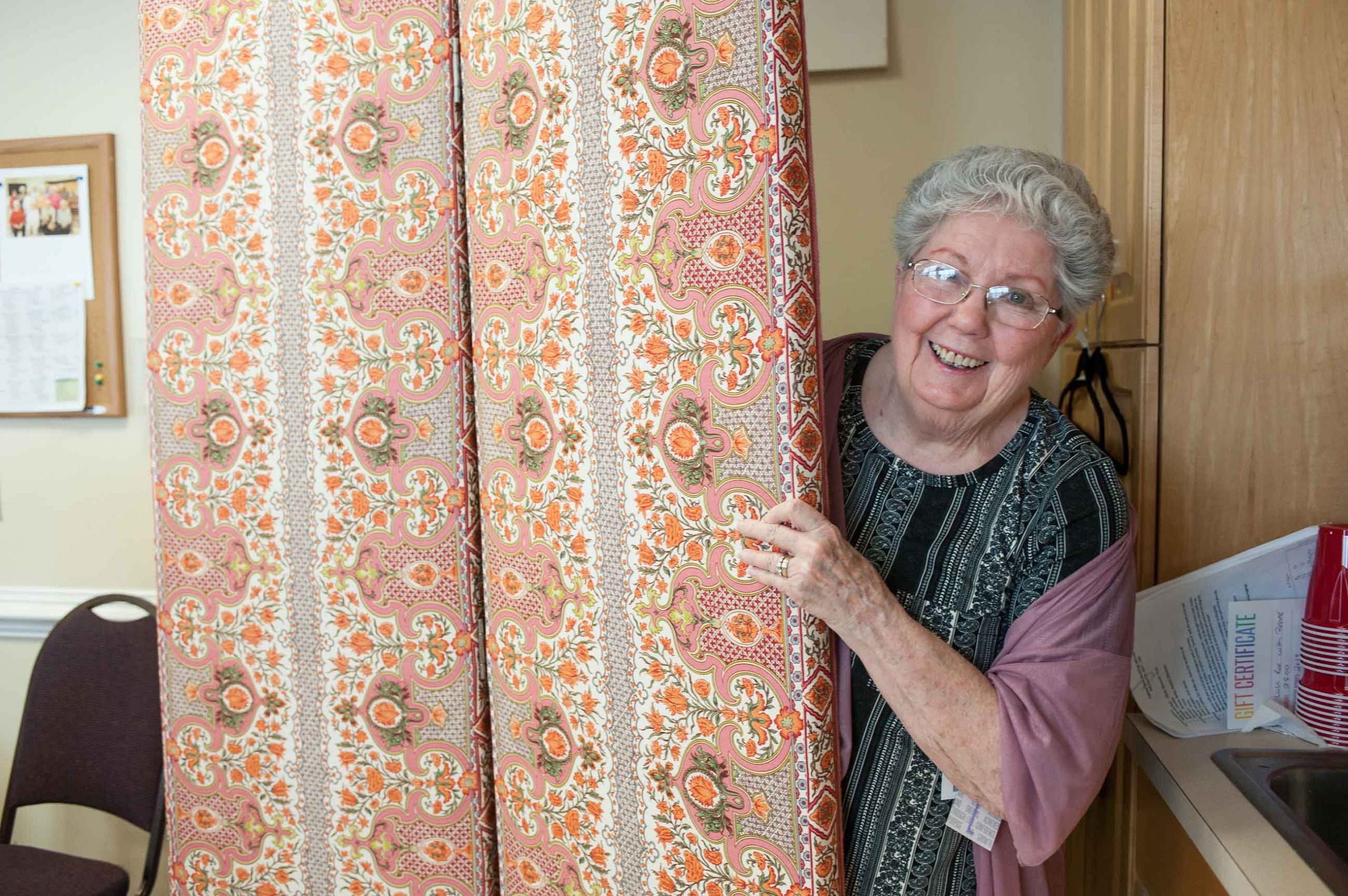 Resident smiling behind decorative panels in a cozy interior