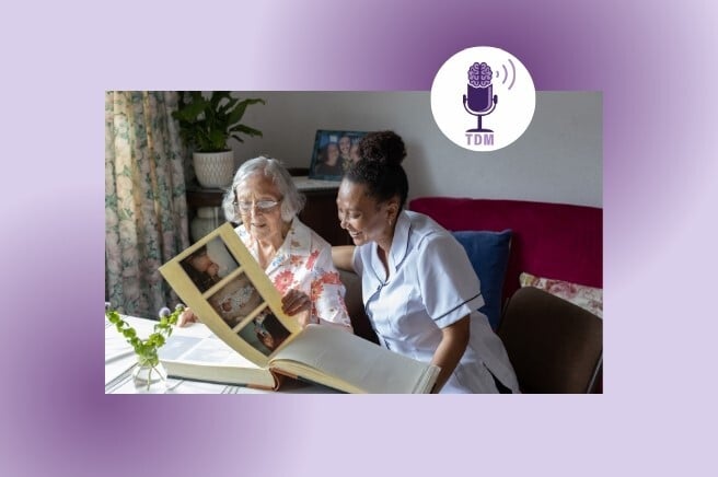 A resident and caregiver looking through a photo album together