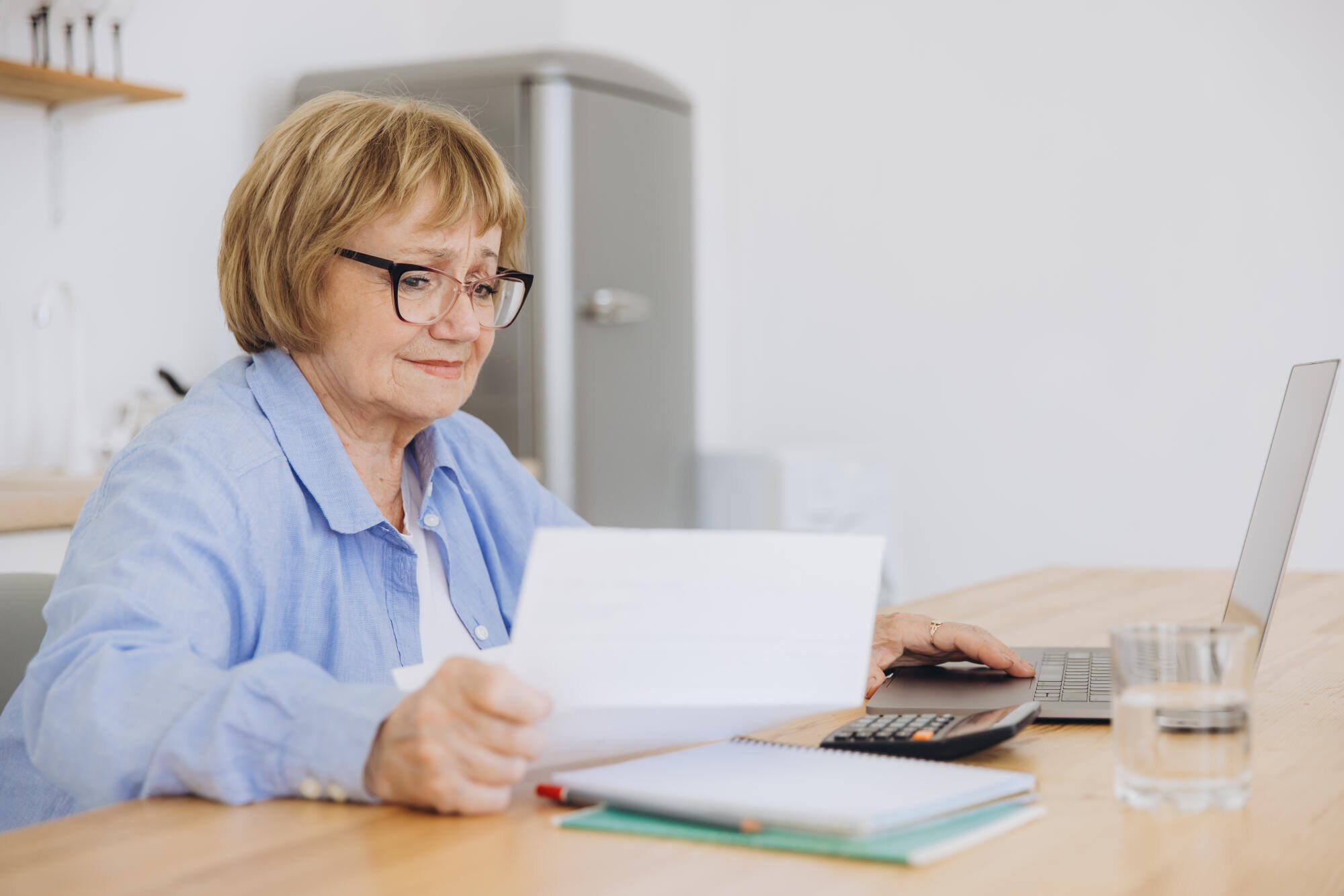 A senior woman working on paperwork at a desk