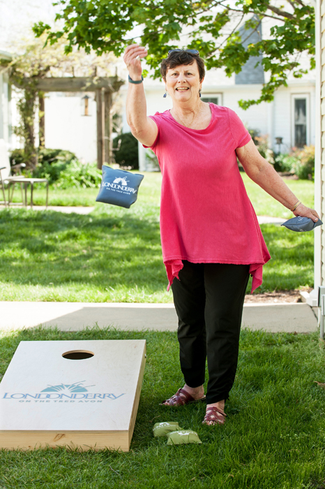 Resident playing cornhole outside at Londonderry