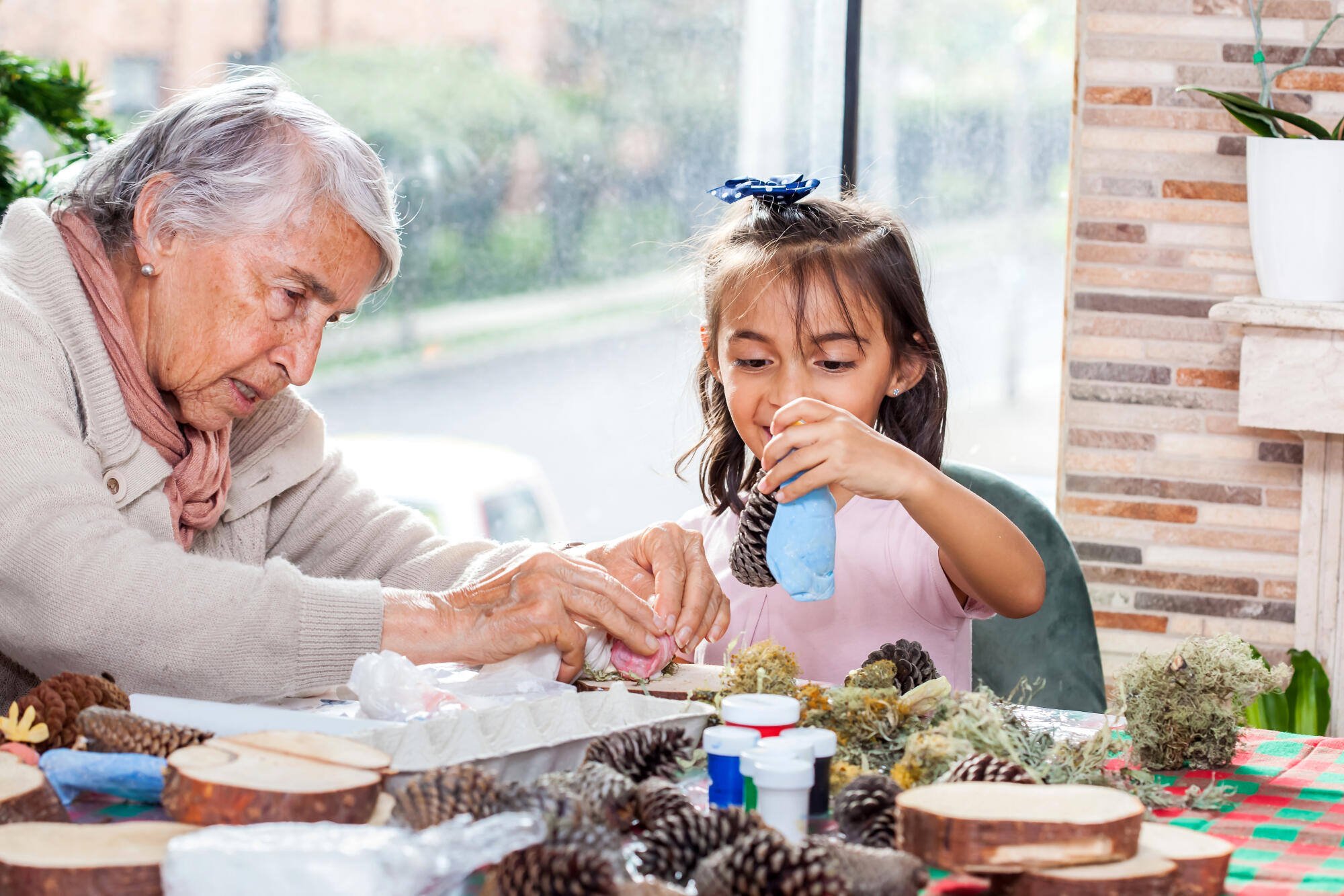 An elderly resident crafts with a young girl