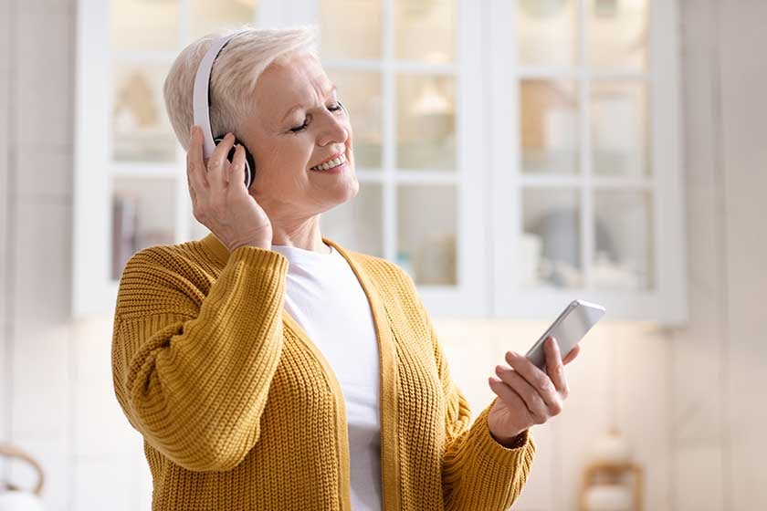 Senior woman listening to music on her phone
