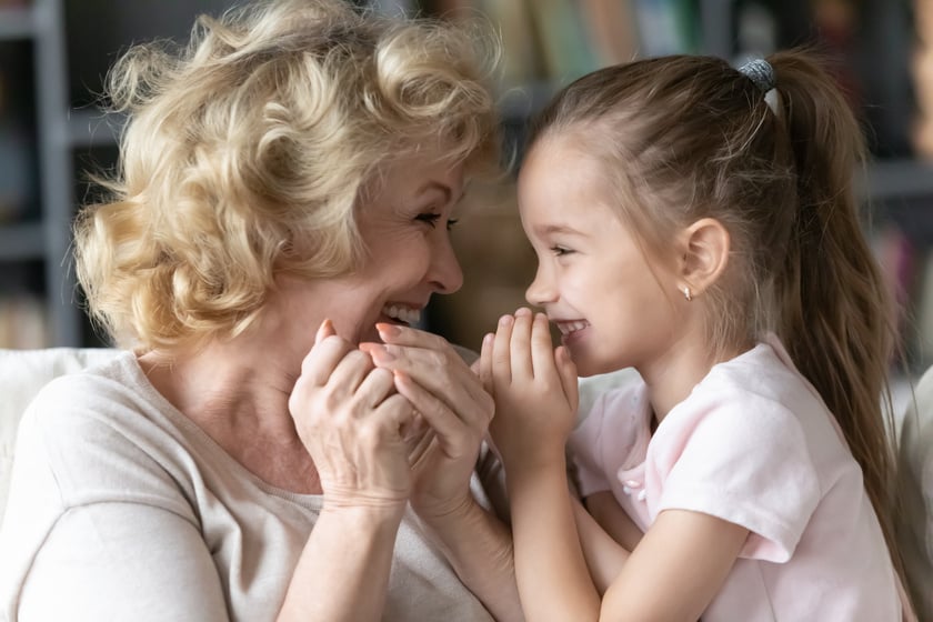 A smiling woman with a girl sharing a joyful moment