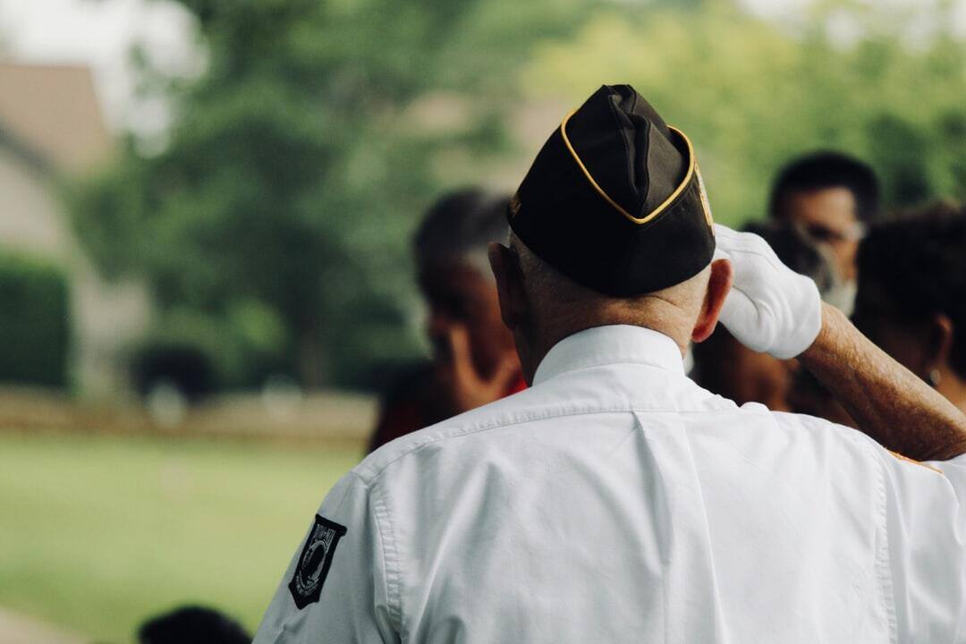 A veteran saluting in an outdoor setting