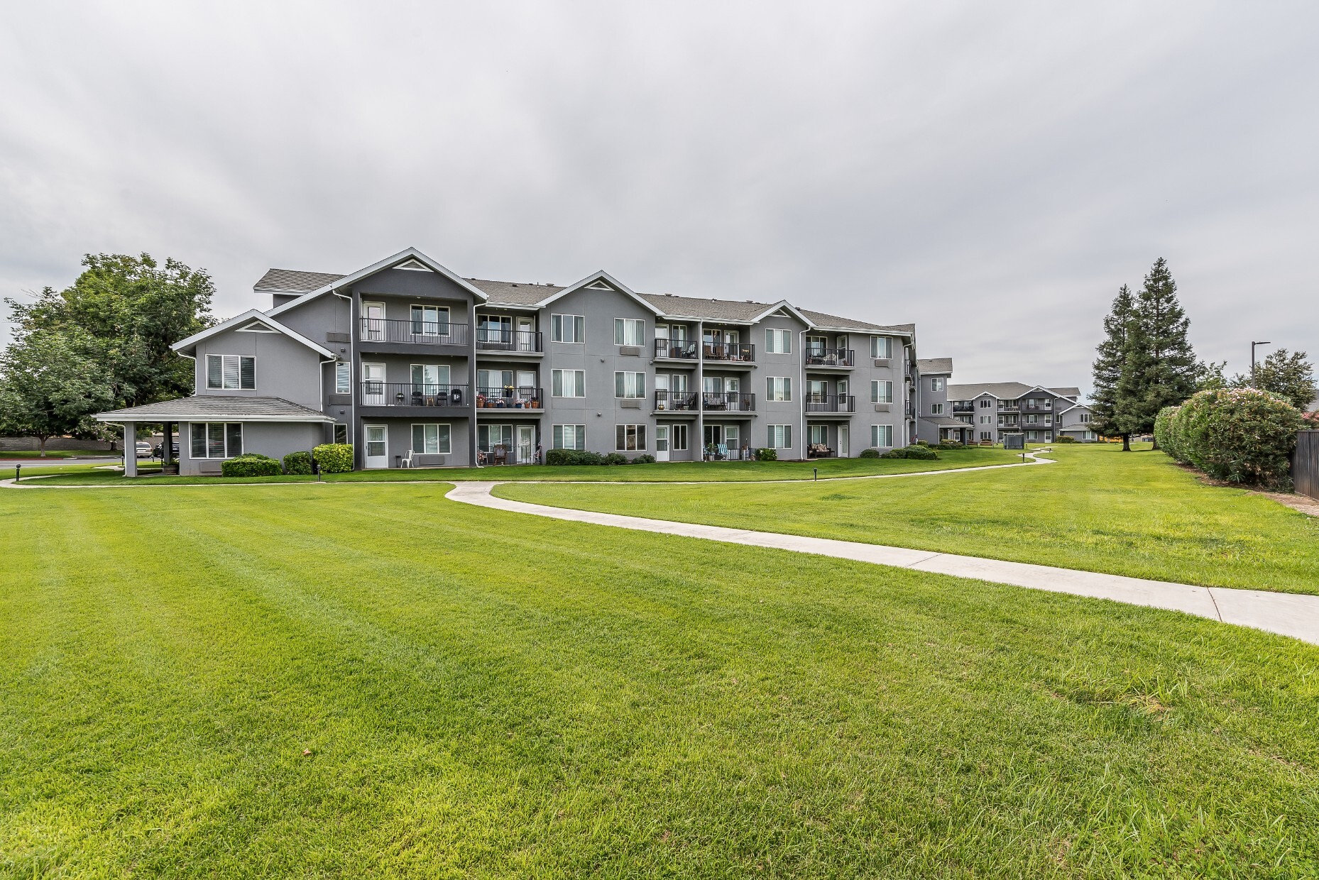 Exterior view of a senior living facility with green lawns