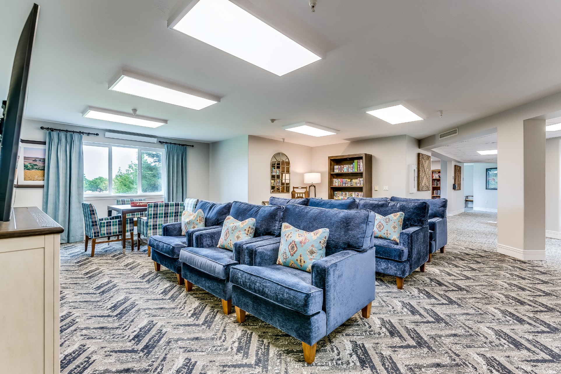 Common area with blue armchairs and natural light