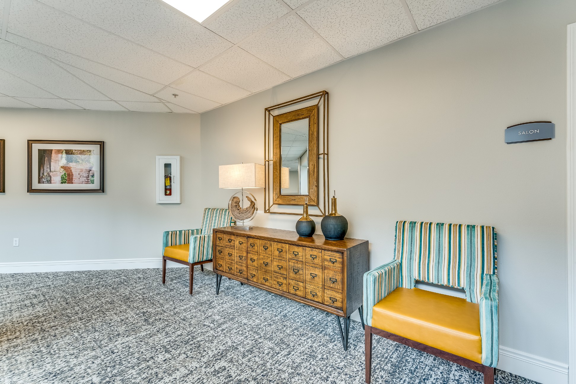 Salon area with chairs and decorative mirror