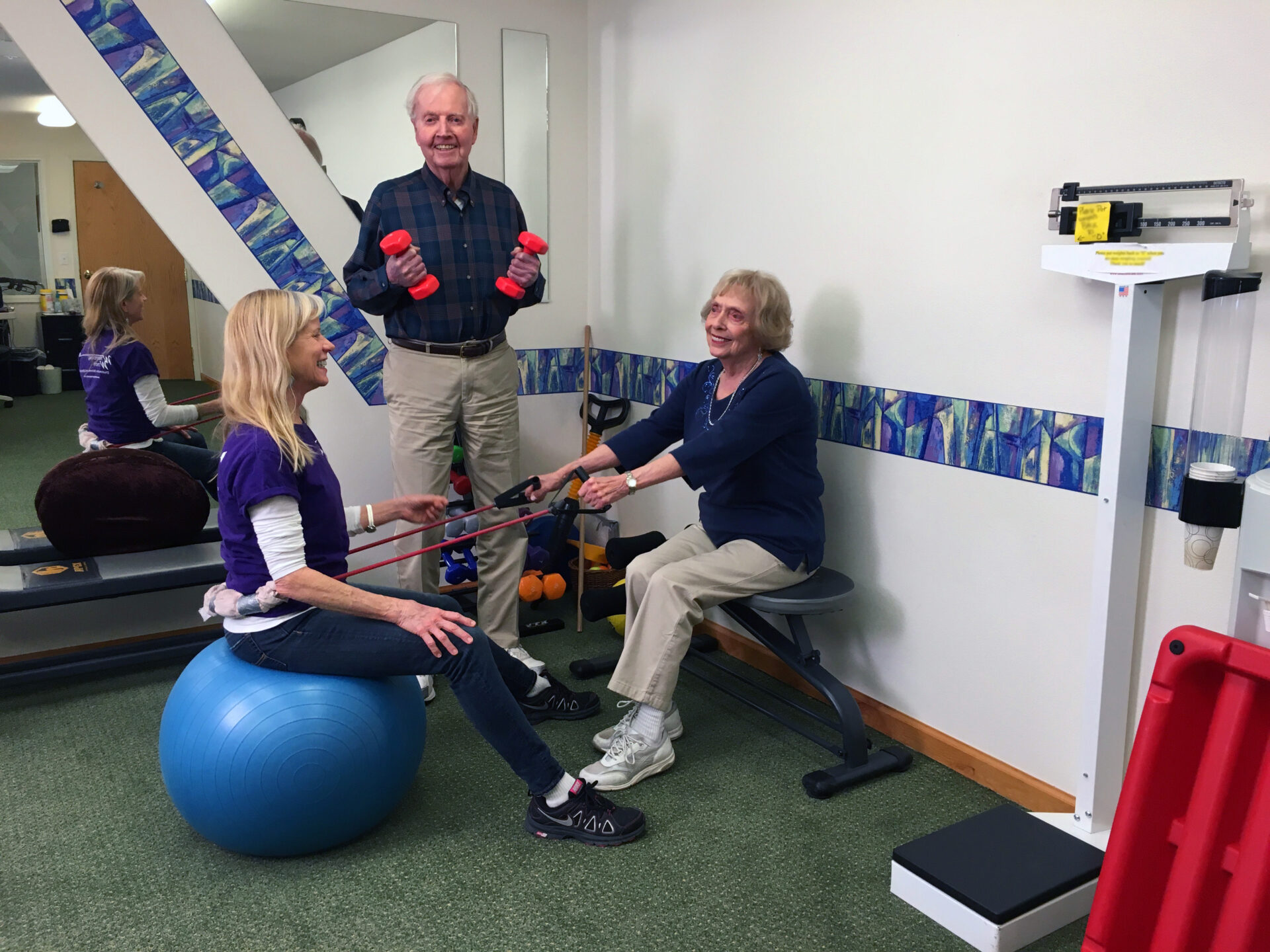 Residents participating in a fitness activity with staff assistance