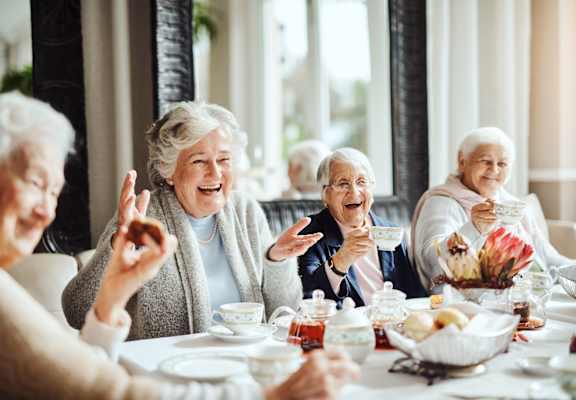 Residents enjoying tea and snacks in a dining room