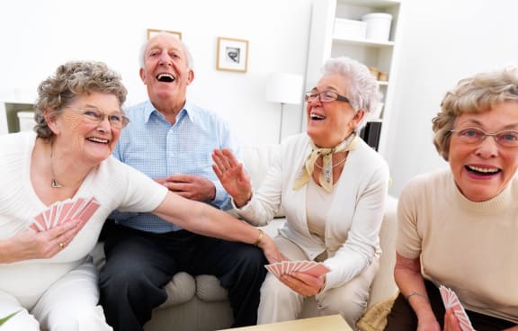 Residents enjoying a card game in a cozy common area