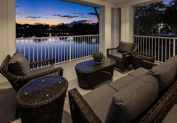 Outdoor seating area overlooking a lake at sunset
