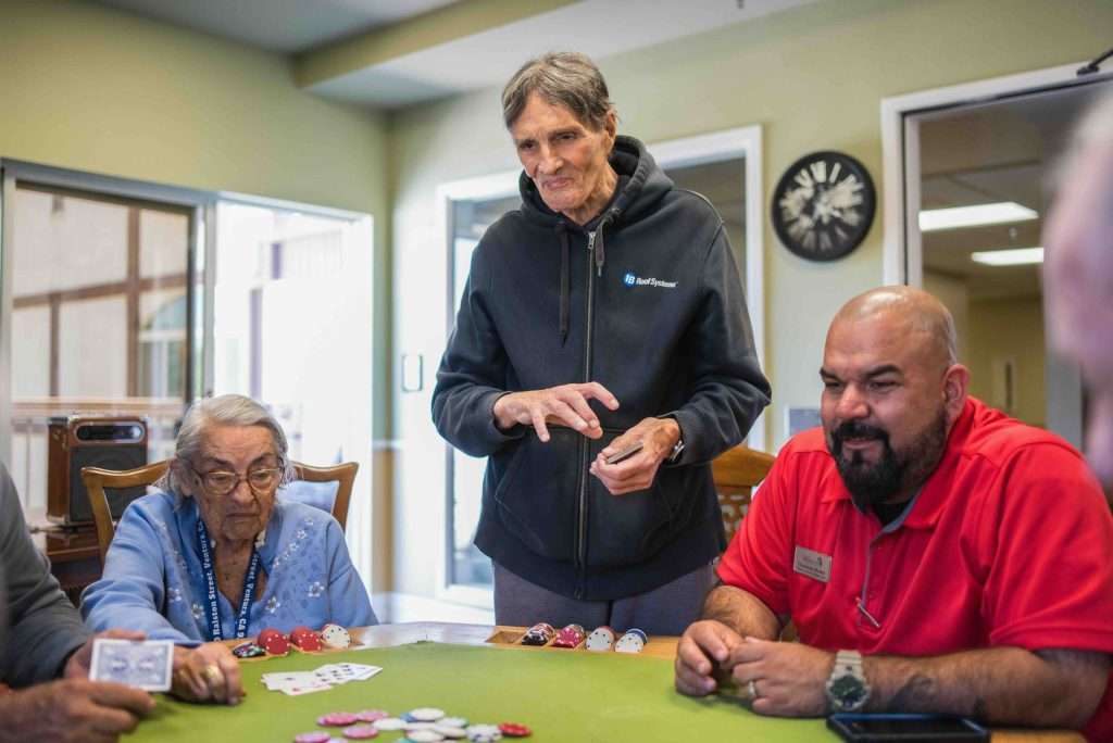 Residents engaged in a card game in a common area