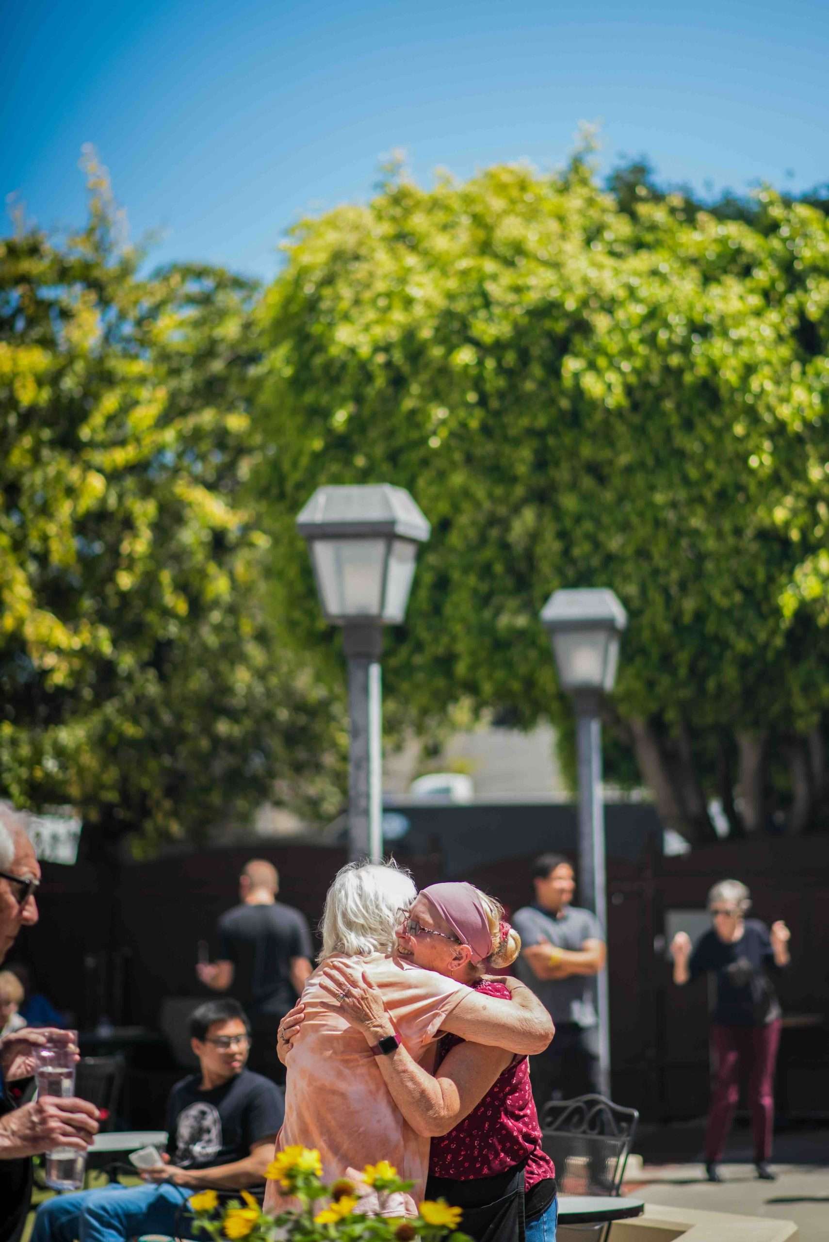 Residents embracing in an outdoor setting with greenery