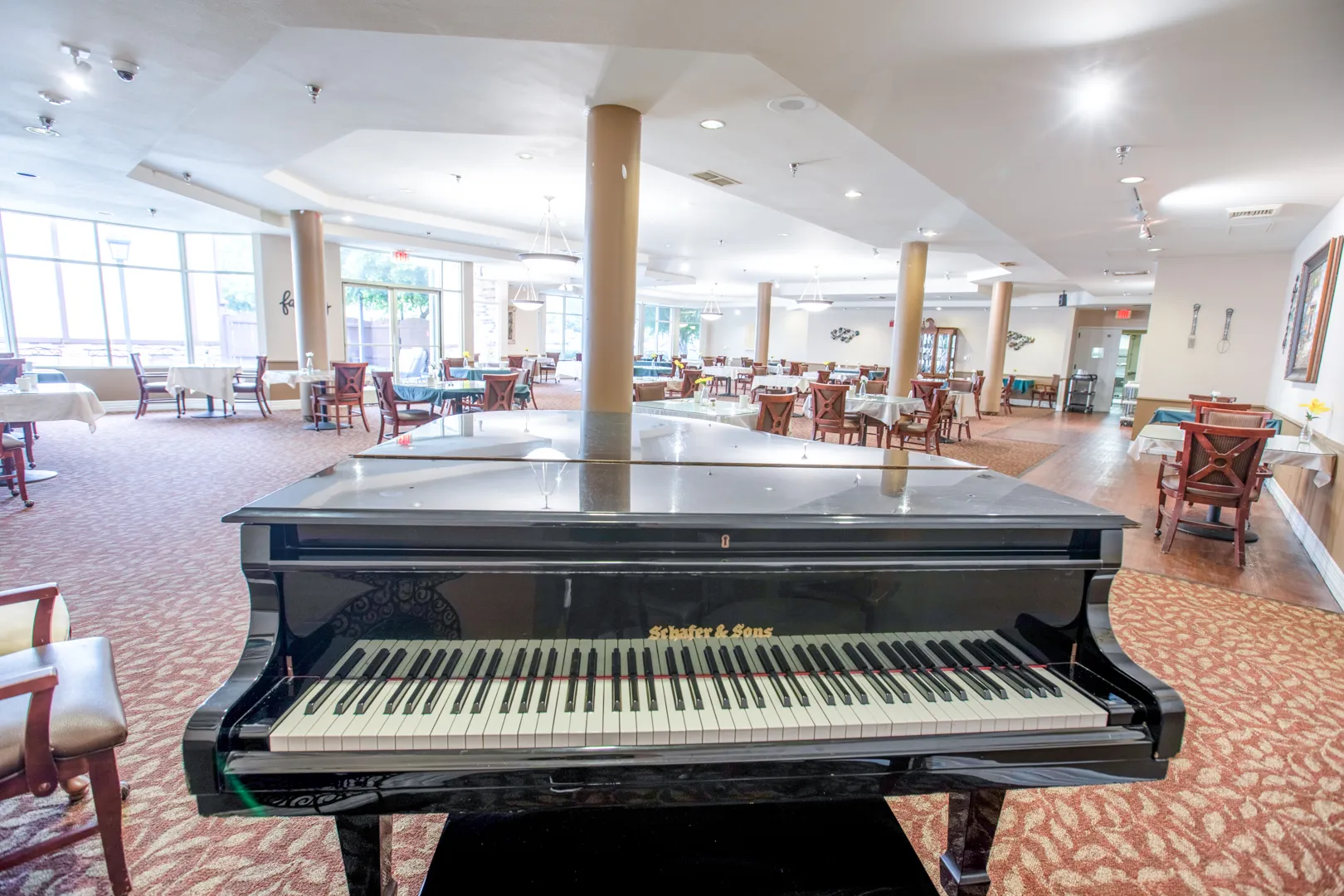 Interior view of a common area with a piano and tables