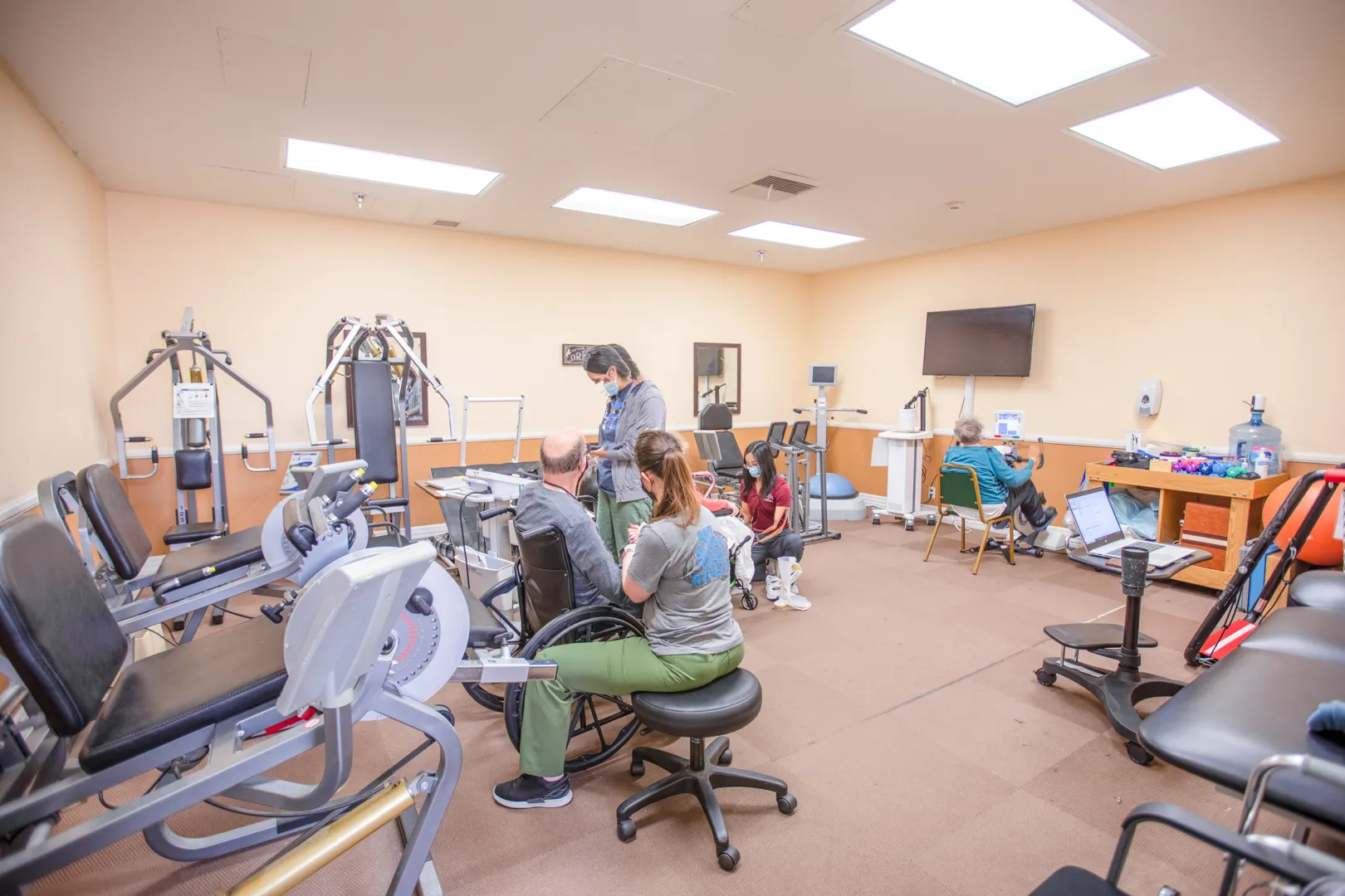 Residents engaging in physical therapy exercises in a fitness room