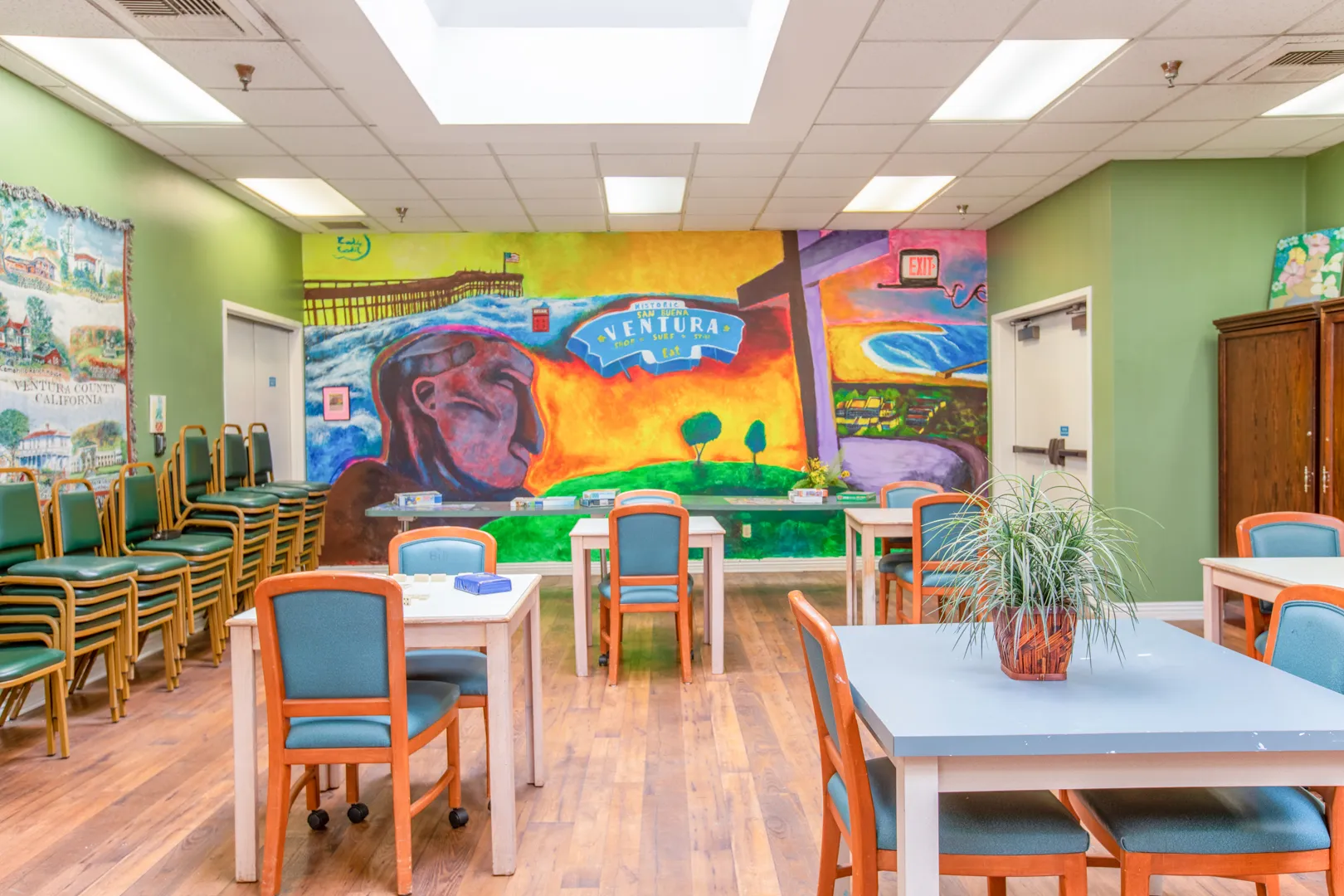 Bright community room with colorful mural and tables