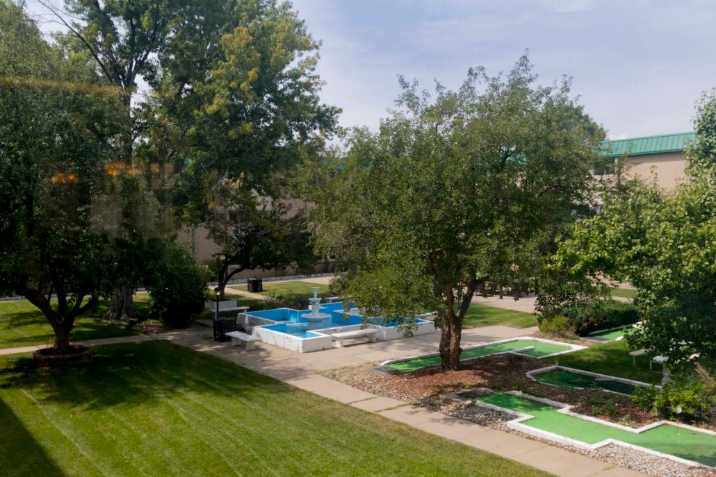 View of landscaped outdoor space with fountains and trees